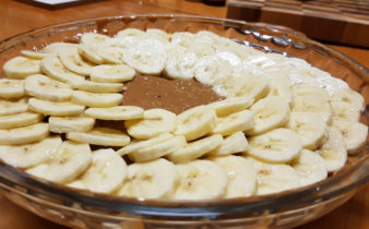 Bananas arranged on top of caramel layer of banoffee pie.