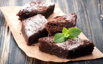 Finish chocolate brownie with raspberry, completed with a sifting of icing sugar