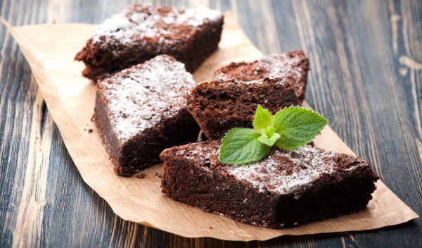 Finish chocolate brownie with raspberry, completed with a sifting of icing sugar