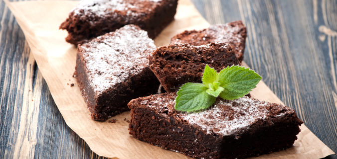 Finish chocolate brownie with raspberry, completed with a sifting of icing sugar